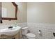 Classic powder room featuring a pedestal sink, toilet, and decorative mirror at 20453 W Daniel Pl, Buckeye, AZ 85396