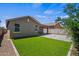 Backyard featuring artificial grass, pavers, and a covered patio, perfect for outdoor living at 21582 W Cocopah St, Buckeye, AZ 85326