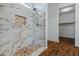 Elegant bathroom featuring a luxurious marble shower with a decorative niche and wood flooring at 21582 W Cocopah St, Buckeye, AZ 85326