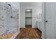 Modern bathroom with stylish marble shower, wood flooring, and convenient closet space at 21582 W Cocopah St, Buckeye, AZ 85326