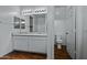 Bright bathroom showcasing double sinks, white cabinets, and a toilet with wood look floors at 21582 W Cocopah St, Buckeye, AZ 85326
