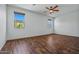 Bright bedroom with wood flooring, windows, and ceiling fan, offering a serene and comfortable space at 21582 W Cocopah St, Buckeye, AZ 85326