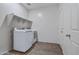 Functional laundry room with a washer, dryer, and shelving units at 21582 W Cocopah St, Buckeye, AZ 85326