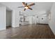 Spacious living area with wood-look flooring and a ceiling fan, open to the kitchen area at 21582 W Cocopah St, Buckeye, AZ 85326