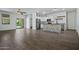 Open-concept living room featuring wood-look tile flooring, a ceiling fan, and access to the kitchen at 21582 W Cocopah St, Buckeye, AZ 85326