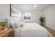 Bright bedroom features a plush white bed, stylish side tables, ceiling fan, and a charming window view at 2225 E Monterosa St, Phoenix, AZ 85016