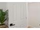 A neutral closet interior with a white door, black handle and leafy decor at 2225 E Monterosa St, Phoenix, AZ 85016