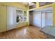 Bedroom with hardwood floors, closet with sliding doors, and large window overlooking the front yard at 2230 N 12Th St # Rear, Phoenix, AZ 85006