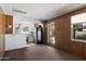 Kitchen area featuring wood paneled walls, updated refrigerator, access to the backyard, and neutral colored carpet at 2230 N 12Th St # Rear, Phoenix, AZ 85006
