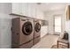 Laundry room with a washer, dryer, white cabinets, and counter space for folding at 22756 N 91St Way, Scottsdale, AZ 85255
