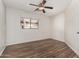Bedroom with wood-look floors and white walls, with ceiling fan and a view from the window at 2424 E Peach Tree Dr, Chandler, AZ 85249