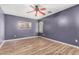 Cozy bedroom with a ceiling fan, wood-look floors, a window and gray walls at 2424 E Peach Tree Dr, Chandler, AZ 85249