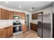 The updated kitchen features stainless steel appliances, wood cabinets and modern flooring at 2424 E Peach Tree Dr, Chandler, AZ 85249