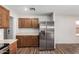 The kitchen features wood cabinets, stainless steel refrigerator and stainless steel appliances at 2424 E Peach Tree Dr, Chandler, AZ 85249