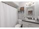 Bright bathroom with modern vanity, decorative mirror, and shower with curtain at 2444 S Noche De Paz --, Mesa, AZ 85202
