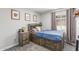 Charming bedroom with a rustic wooden bed frame, built-in drawers, and baseball-themed decorations at 2444 S Noche De Paz --, Mesa, AZ 85202