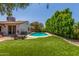 Serene backyard with a private pool and manicured artificial grass, creating a relaxing oasis at 2444 S Noche De Paz --, Mesa, AZ 85202