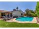 A kidney-shaped pool with stone decking and turf is surrounded by lounge chairs in the backyard at 2444 S Noche De Paz --, Mesa, AZ 85202