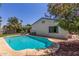 A beautiful backyard pool with stone trim is surrounded by patio and lush flowering foliage at 2444 S Noche De Paz --, Mesa, AZ 85202