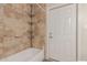 Tiled bathtub with convenient in-shower shelving and a white door at 2616 S El Dorado --, Mesa, AZ 85202