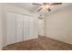 This cozy bedroom features neutral walls, carpet, a ceiling fan, and a spacious closet at 2616 S El Dorado --, Mesa, AZ 85202