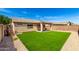 Well-maintained backyard with artificial grass, a covered patio and privacy walls for a serene outdoor retreat at 30212 N Sunray Dr, San Tan Valley, AZ 85143