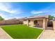 Inviting backyard featuring lush artificial grass and a covered patio, perfect for outdoor relaxation and entertainment at 30212 N Sunray Dr, San Tan Valley, AZ 85143