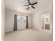 Cozy bedroom featuring a ceiling fan, neutral carpet, and a large window at 30212 N Sunray Dr, San Tan Valley, AZ 85143
