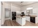 Well-lit kitchen with white cabinets, a kitchen island, and black appliances at 30212 N Sunray Dr, San Tan Valley, AZ 85143
