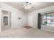 Bright living room featuring neutral carpet and ceiling fan, with a glimpse of the hallway at 30212 N Sunray Dr, San Tan Valley, AZ 85143