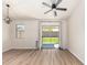 Open-concept living room with wood floors, neutral walls, and sliding glass doors to backyard at 30212 N Sunray Dr, San Tan Valley, AZ 85143