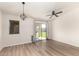Bright living room with wood-look flooring, modern light fixtures, and sliding door access to the backyard at 30212 N Sunray Dr, San Tan Valley, AZ 85143