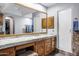 Bathroom with natural wood cabinets, walk-in shower, marble countertops, and large vanity mirror at 322 E Gary Cir, Mesa, AZ 85201