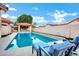 Stunning backyard oasis featuring a sparkling pool, covered patio, and comfortable lounge chairs at 322 E Gary Cir, Mesa, AZ 85201