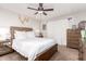 Comfortable bedroom showcasing a wood bed frame, ceiling fan, and warm carpet at 3256 W Libby St, Phoenix, AZ 85053