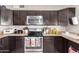 Galley kitchen features stainless steel appliances, dark cabinets, and speckled granite countertops at 3256 W Libby St, Phoenix, AZ 85053