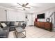 Bright living room with tile floors, a cozy sectional, and modern entertainment setup, ideal for relaxation and enjoyment at 3256 W Libby St, Phoenix, AZ 85053