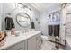 Stylish bathroom features modern fixtures, a round mirror, and a marble-tiled shower at 3848 W Kings Ave, Phoenix, AZ 85053
