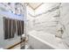 A bathtub with marble-like tile surround, with a shower head at 3848 W Kings Ave, Phoenix, AZ 85053