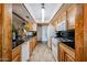 Well-equipped kitchen featuring modern appliances, tile countertops, and natural wood cabinetry at 3848 W Kings Ave, Phoenix, AZ 85053