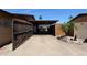 Open wooden gate leading to a carport area, creating a welcoming entrance to the property at 3848 W Kings Ave, Phoenix, AZ 85053