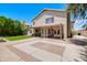 A spacious backyard featuring a large brick and concrete patio, lawn, and mature landscaping at 3921 W Jasper Dr, Chandler, AZ 85226
