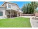 A spacious backyard featuring a covered patio, lawn, and mature landscaping at 3921 W Jasper Dr, Chandler, AZ 85226
