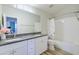 Bathroom with dual vanity, granite counters, large mirror, and tub with shower at 3921 W Jasper Dr, Chandler, AZ 85226