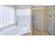 Bright bathroom featuring a soaking tub with glass block window and a tiled walk-in shower at 3921 W Jasper Dr, Chandler, AZ 85226