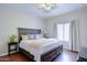 Bedroom with a ceiling fan, wooden floors, large bed, and a view to the outside at 3921 W Jasper Dr, Chandler, AZ 85226