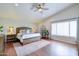 Serene bedroom featuring a ceiling fan, large window, and plush bedding, offering a relaxing retreat at 3921 W Jasper Dr, Chandler, AZ 85226