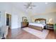 Inviting main bedroom with warm wood floors, ceiling fan, and a luxurious bed complemented by stylish decor at 3921 W Jasper Dr, Chandler, AZ 85226