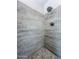 Shower with a rainfall shower head, with designer gray-toned tiling with stone tile floor detail at 3921 W Jasper Dr, Chandler, AZ 85226