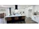 Modern kitchen featuring a large island with seating, sleek countertops, and stylish black and white cabinetry at 4125 W Villa Rita Dr, Glendale, AZ 85308